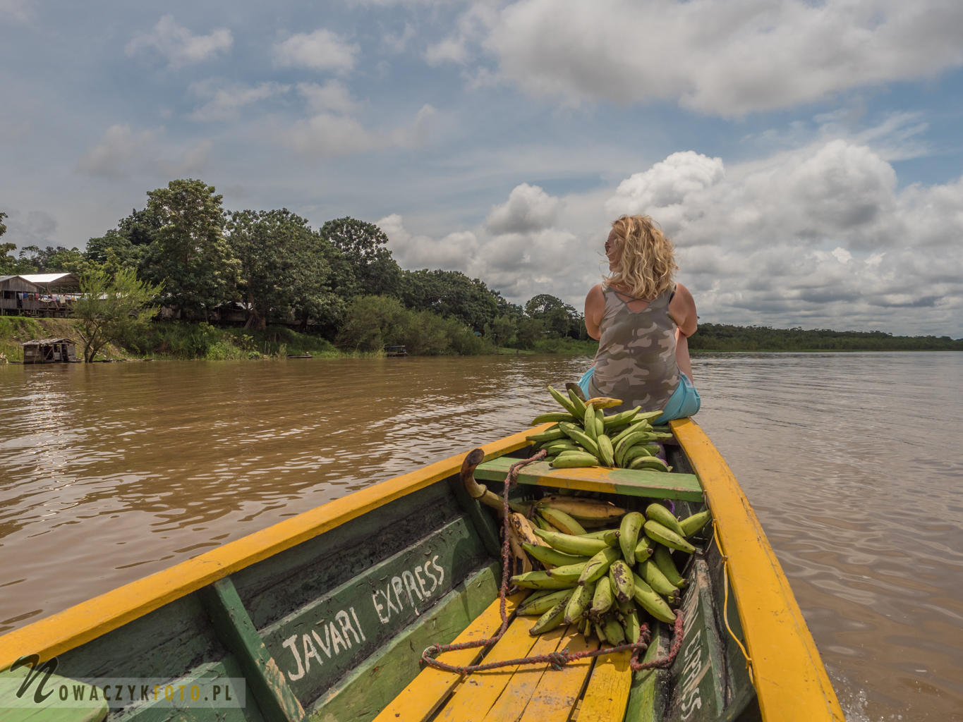 Banany i kobieta na czubku łodzi płynącej rzeką przez dżunglę