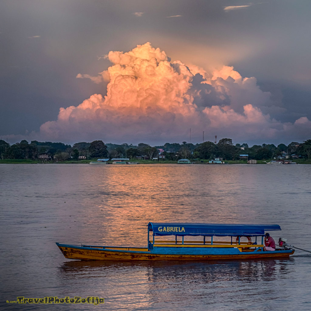 Zachód słońca na Amazonce i płynąca łódka